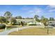 Charming single-story home with well-manicured lawn, mature trees, and a long driveway leading to the attached garage at 5170 Ne 64Th Ave, Silver Springs, FL 34488
