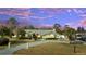 Inviting single-story home with a well-manicured lawn, mature trees, and a long driveway leading to the attached garage at 5170 Ne 64Th Ave, Silver Springs, FL 34488