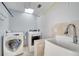 Functional laundry room features a skylight, washer, dryer, and utility sink at 5170 Ne 64Th Ave, Silver Springs, FL 34488