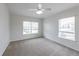 Bright bedroom with natural light from two windows and a ceiling fan for added comfort at 6612 S Goldenrod Rd # 104A, Orlando, FL 32822