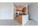 Open concept kitchen featuring wooden cabinetry, stainless steel appliances, and a breakfast bar at 6612 S Goldenrod Rd # 104A, Orlando, FL 32822
