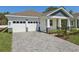 An inviting one-story home boasts a two-car garage and a charming front entryway with lush landscaping at 8007 Colby Cir, Orlando, FL 32817