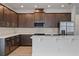 Modern kitchen with dark cabinets, white quartz countertops, and stainless steel appliances at 8013 Colby Cir, Orlando, FL 32817