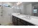 Modern bathroom with double sinks, white countertops, and a walk-in shower with glass door at 8013 Colby Cir, Orlando, FL 32817