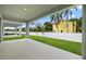 A covered patio looks out onto a fenced yard with a yellow house in the background at 8013 Colby Cir, Orlando, FL 32817