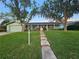 Charming home with green lawn and mature trees, complemented by a welcoming walkway to the front door at 805 Glen Arden Way, Altamonte Springs, FL 32701