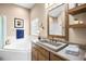Bathroom with a vanity, a concrete sink, and a soaking tub by a window at 8426 Foxworth Cir # 44, Orlando, FL 32819