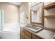 Bathroom with a vanity, a concrete sink, and a soaking tub by a window at 8426 Foxworth Cir # 44, Orlando, FL 32819