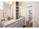 Bathroom with double vanity, grey cabinets, and a peek into another room at 8426 Foxworth Cir # 44, Orlando, FL 32819