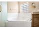 Bright bathroom featuring a white corner bathtub with glass block window at 8426 Foxworth Cir # 44, Orlando, FL 32819