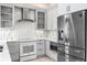 Modern kitchen with stainless steel appliances, gray cabinetry, white countertops and stylish backsplash at 8426 Foxworth Cir # 44, Orlando, FL 32819