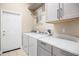 Bright laundry room featuring modern washer, dryer, countertops and cabinetry at 8426 Foxworth Cir # 44, Orlando, FL 32819