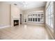 Bright living room with a fireplace, tile floors, a ceiling fan, and large shuttered windows at 8426 Foxworth Cir # 44, Orlando, FL 32819