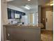 Open kitchen with modern appliances, granite countertops, dark cabinets, and a breakfast bar at 8763 Worldquest Blvd # 5103, Orlando, FL 32821