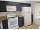 Modern kitchen featuring white appliances, granite countertops, and ample cabinet space at 8763 Worldquest Blvd # 5103, Orlando, FL 32821