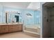 Bright bathroom featuring a large jacuzzi tub with a shower and large mirrors at 907 Almond Tree Cir, Orlando, FL 32835