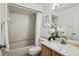 Cozy bathroom with tiled bathtub and shower, granite vanity, and decorative white flowers at 907 Almond Tree Cir, Orlando, FL 32835