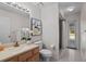 Bright bathroom featuring a granite vanity, decorative art, and a tiled shower at 907 Almond Tree Cir, Orlando, FL 32835