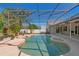 Screened pool with concrete patio surrounded by palm trees in a backyard at 907 Almond Tree Cir, Orlando, FL 32835