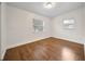 Bright bedroom featuring hardwood floors and natural light from two windows with bright white walls at 908 Cannes Pl, Orlando, FL 32808