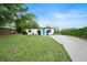 Charming single-story home with a well-manicured lawn, a long driveway, and a vibrant blue front door at 908 Cannes Pl, Orlando, FL 32808