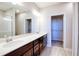 Bathroom featuring double vanity with hard surface counters, wood cabinets, and a separate walk-in closet at 9314 Bolshoi Aly, Winter Garden, FL 34787