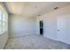 Bedroom featuring plush carpeting, neutral paint, a large window, and closet with an attached bathroom at 9314 Bolshoi Aly, Winter Garden, FL 34787