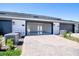 Exterior view of garage with modern doors, paver driveway, and landscaped curb appeal at 9314 Bolshoi Aly, Winter Garden, FL 34787