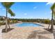 A beautiful community pool on a bright sunny day with palm trees and lots of seating at 9314 Bolshoi Aly, Winter Garden, FL 34787