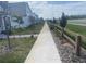 View of houses with palm trees and fresh green grass from the sidewalk and street at 9314 Bolshoi Aly, Winter Garden, FL 34787