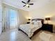 Cozy bedroom with decorative bedding, modern ceiling fan, and natural light at 9661 Portofino Dr, Orlando, FL 32832