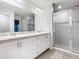 A bright and modern bathroom with double sinks and a glass-enclosed shower at 405 Bandon Dunes Loop, Davenport, FL 33837