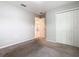 Well-lit bedroom with carpet and a closet featuring paneled doors and an open doorway at 405 Bandon Dunes Loop, Davenport, FL 33837