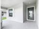 Inviting front porch with neutral tones featuring a modern front door with decorative glass and sidelight at 405 Bandon Dunes Loop, Davenport, FL 33837