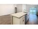 Bright kitchen island with stainless steel dishwasher, sink, and granite countertops at 405 Bandon Dunes Loop, Davenport, FL 33837