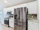 Modern kitchen features stainless steel appliances and sleek white cabinetry at 405 Bandon Dunes Loop, Davenport, FL 33837
