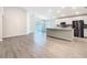 Open-concept living room and kitchen featuring wood floors and modern appliances at 405 Bandon Dunes Loop, Davenport, FL 33837