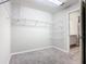 Spacious walk-in closet with wire shelving and neutral carpeting, ready to be organized at 405 Bandon Dunes Loop, Davenport, FL 33837
