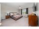 Bright bedroom featuring carpet, a ceiling fan, and comfortable furniture at 10849 Wyne Tree Ct, Orlando, FL 32824