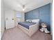 Cozy bedroom with a blue accent wall, comfortable bed, and a well-lit window at 10849 Wyne Tree Ct, Orlando, FL 32824