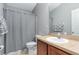 Bathroom features a single sink vanity and tiled shower with a gray and white striped shower curtain at 10876 Eclipse Lily Way # 60, Orlando, FL 32832