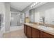 Bathroom features double sinks, vanity with wooden cabinets, and a glass-enclosed shower at 10876 Eclipse Lily Way # 60, Orlando, FL 32832