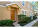 Inviting home exterior with neatly trimmed landscaping, a bright orange door, and a covered porch at 10876 Eclipse Lily Way # 60, Orlando, FL 32832