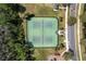 Aerial shot of well-maintained tennis courts with lush greenery and trees surrounding the perimeter at 10876 Eclipse Lily Way # 60, Orlando, FL 32832