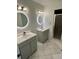 Bathroom boasts dual sinks, trendy light fixtures and glass-enclosed shower at 1130 W Minnehaha Ave, Clermont, FL 34711