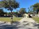 Charming single-story home with a well-manicured lawn, mature trees, and a long driveway at 1130 W Minnehaha Ave, Clermont, FL 34711