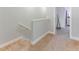 Upstairs hallway with carpeted flooring, white trim, and a view of the staircase at 1284 Spotted Sandpiper Loop, Winter Springs, FL 32708