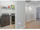 Modern laundry room with front loading washer and dryer, wire shelving and tile flooring at 1284 Spotted Sandpiper Loop, Winter Springs, FL 32708