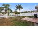 Spacious fenced backyard features a pond view, mature palm trees, and a brick patio area at 13212 Briar Forest Ct, Orlando, FL 32828