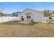 Backyard with a patio, grill, lawn, and white fence bordering the property at 13212 Briar Forest Ct, Orlando, FL 32828